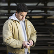 Caucasian worker using cell phone in factory