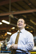 Smiling Hispanic foreman standing in factory