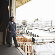 Hispanic worker standing on factory loading dock