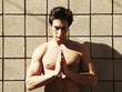 Shirtless Caucasian man praying outdoors