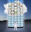 Mixed race businessman looking at towering monitors