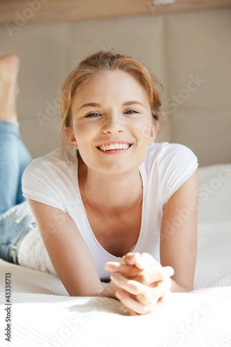 Photo: smiling teenage girl on a bed smiling teenage girl on a bed