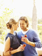 Glamorous Caucasian couple drinking cocktails outdoors