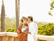 Glamorous Caucasian couple drinking red wine and kissing outdoors