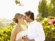 Glamorous Caucasian couple drinking red wine and kissing outdoors