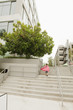 Caucasian boy in superhero costume going up urban stairs
