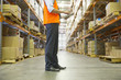 Manager using digital tablet in warehouse