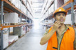 Worker talking on walkie talkie in warehouse