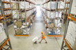 Worker pushing hand truck in warehouse