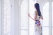 Pacific Islander woman looking out window