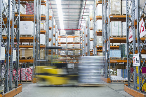 Photo: Forklift on the move in warehouse Forklift on the move in warehouse