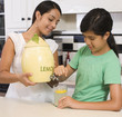 Hispanic mother and daughter pouring lemonade