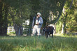 Man walking with bottles and calf through field