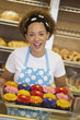Black baker holding tray of cupcakes