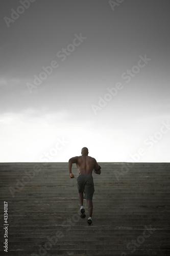 Photo: Black man running up stairs Black man running up stairs