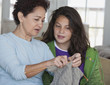 Grandmother teaching granddaughter to knit
