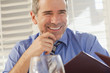 Smiling Caucasian businessman holding menu in restaurant