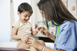 Indian doctor testing baby's reflexes in doctor's office