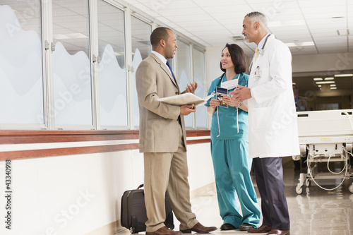 Photo: Doctors and drug salesman talking in hospital Doctors and drug salesman talking in hospital