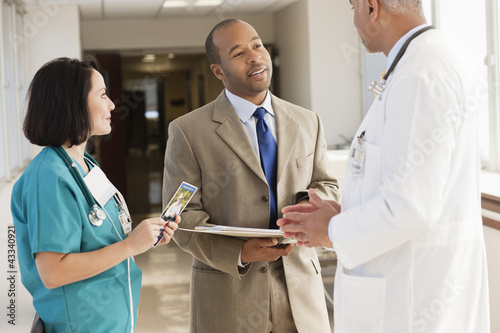 Photo: Doctors and drug salesman talking in hospital Doctors and drug salesman talking in hospital