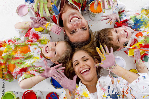 Photo: Hispanic family covered in paint laying on floor Hispanic family covered in paint laying on floor