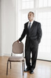 Mixed race businessman standing near chair