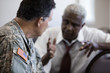 Soldier sitting in chair talking to businessman