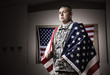 Hispanic soldier wrapped in American flag