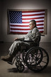 Hispanic soldier in wheelchair near American flag