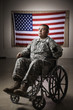 Hispanic soldier in wheelchair near American flag