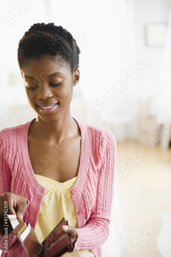 Photo: Black woman taking money out of her wallet Black woman taking money out of her wallet