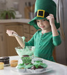 Caucasian girl making St. Patrick's cupcakes