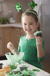 Caucasian girl making St. Patrick's cupcakes