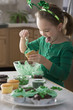 Caucasian girl making St. Patrick's cupcakes