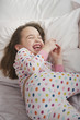 Grinning Caucasian girl laying in bed