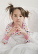 Serious Caucasian girl sitting in bed