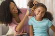 Mixed race mother brushing daughter's hair