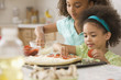 Mixed race sisters making pizza