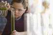 Caucasian girl doing chemistry experiment in classroom