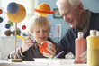 Caucasian man helping grandson with science project