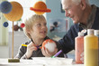 Caucasian man helping grandson with science project