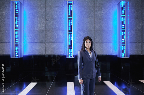 Photo: Asian businesswoman standing in lobby Asian businesswoman standing in lobby