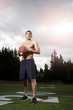Hispanic athlete holding football