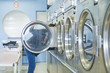 Foto: Hispanic woman doing laundry in self-service laundry facility Hispanic woman doing laundry in self-service laundry facility