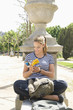 Hispanic woman looking at guide book in park