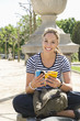 Hispanic woman looking at guide book in park