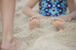 Caucasian girl buried in the sand on beach