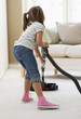 Girl vacuuming living room floor