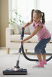Girl vacuuming living room floor