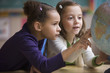 Students looking at globe in classroom